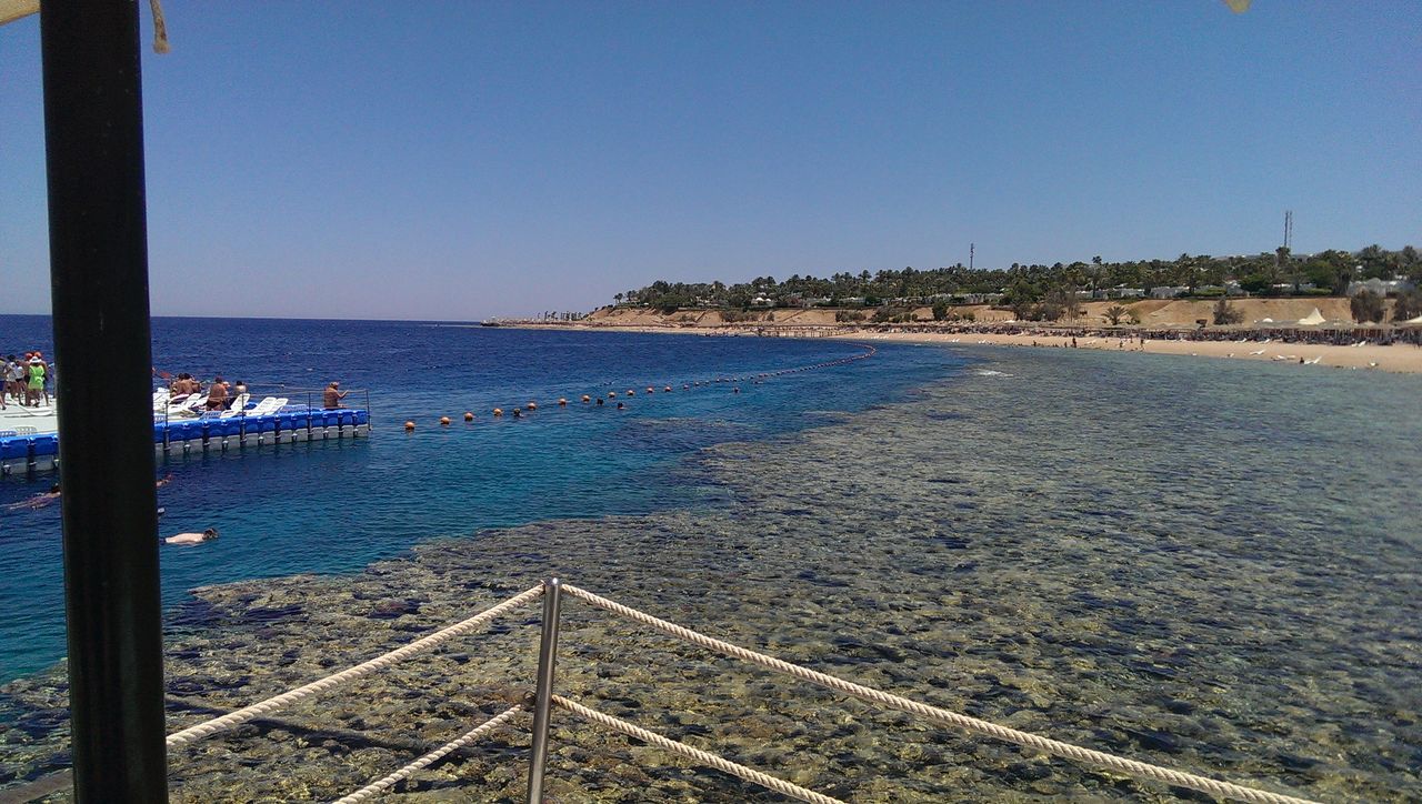 sea, water, clear sky, horizon over water, blue, tranquil scene, tranquility, scenics, copy space, beauty in nature, nature, railing, incidental people, idyllic, beach, sky, day, sunlight, outdoors, transportation