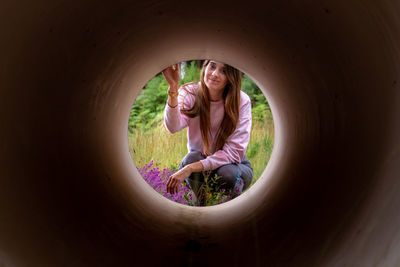 Portrait of woman seen through pipe