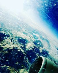 Close-up of airplane wing over sea against sky