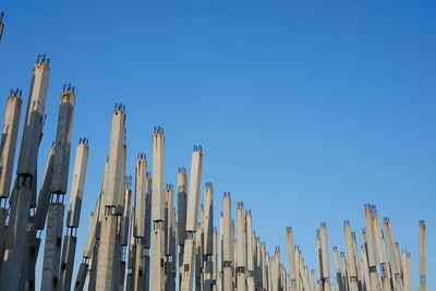 Low angle view of fence against clear blue sky