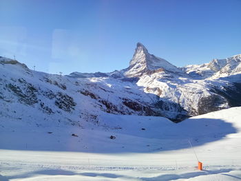 Scenic view of snowcapped mountains against blue sky