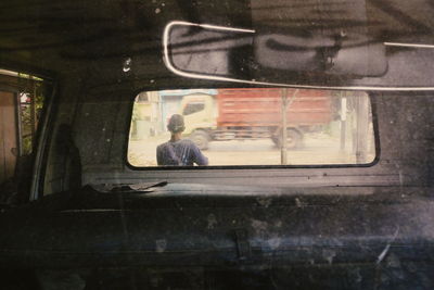 Reflection of man sitting in car window