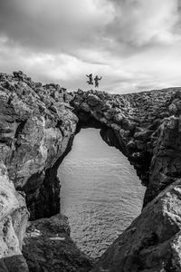 Rock formations by sea against sky