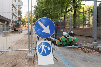 Road sign against trees in city