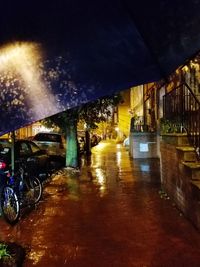 Illuminated street against sky at night