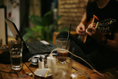 Midsection of person playing guitar in cafe