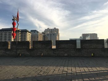 Buildings in city against cloudy sky