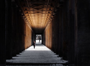 Rear view of person walking on corridor of building