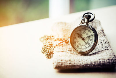 Close-up of pocket watch on table