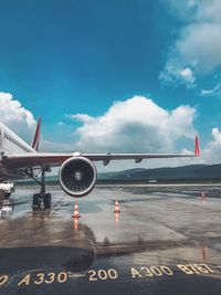 Airplane on airport runway against sky