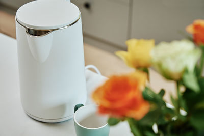 Electric kettle and cup for tea on table