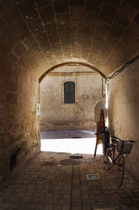 Bicycle parked in corridor by wall