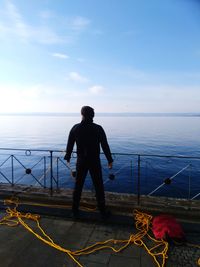 Full length of man looking at sea against sky