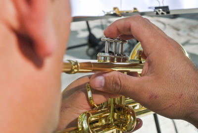 Midsection of street musician playing trumpet on street