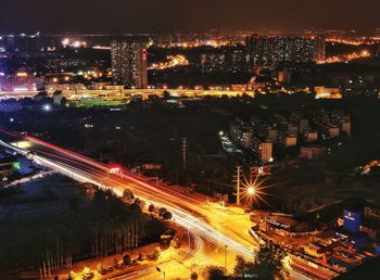 High angle view of illuminated city street and buildings at night