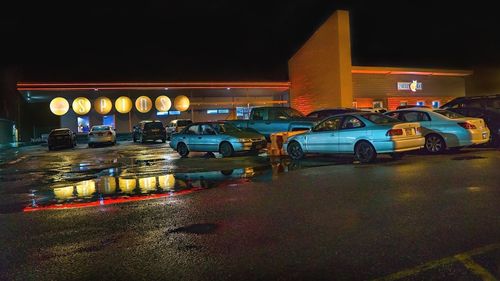 Illuminated cars on road in city at night