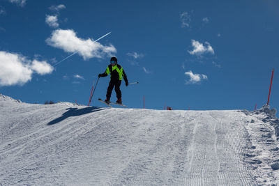 Man skiing on snowcapped mountain against sky