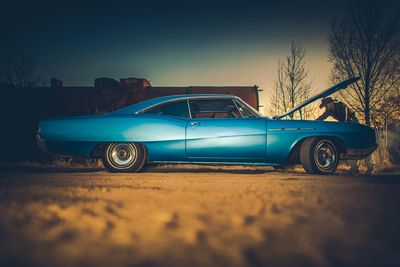 Side view of old car on land against sky