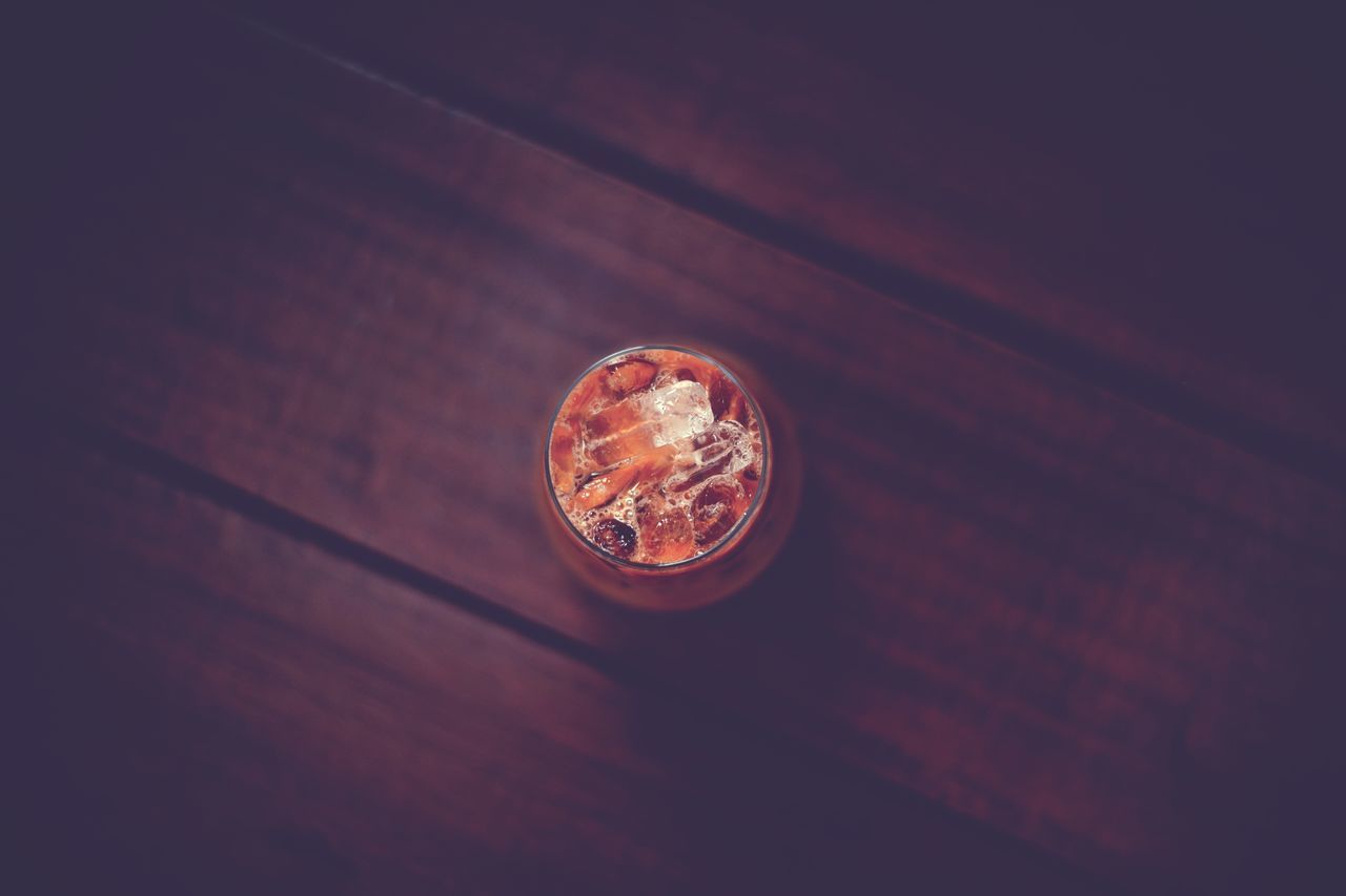 circle, no people, indoors, finance, wealth, macro photography, wood, currency, coin, high angle view, single object, close-up, darkness, table, light, business, still life