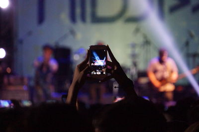 People photographing through smart phone at concert