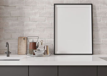 Empty vertical picture frame standing in modern kitchen. mock up interior 