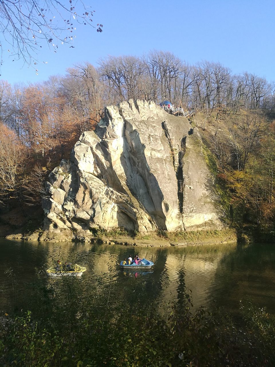 REFLECTION OF TREES ON ROCKS AGAINST SKY