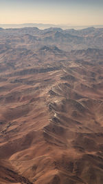 Aerial view of snowcapped mountains against sky during sunset