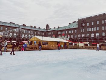 Group of people in snow against buildings in city