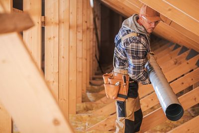 Side view of architect carrying equipment on attic