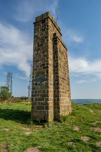 Stone structure on field against sky