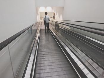 Rear view of man walking on steps