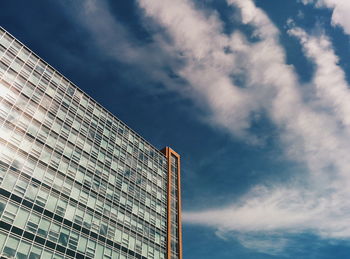 Low angle view of modern building against cloudy sky