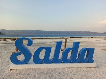 Text on beach against sky
