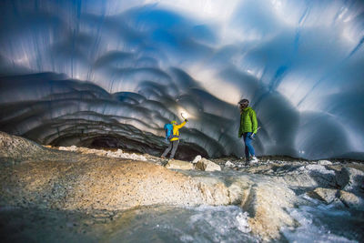 Adventurous couple exploring an ice cave.