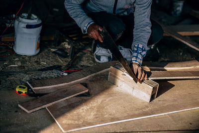 Low section of man working on wood