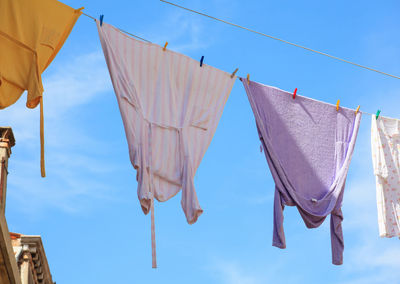 Low angle view of clothes drying on blue sky