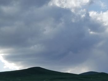 Scenic view of mountains against cloudy sky