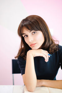 Young thoughtful businesswoman sitting at desk in home office