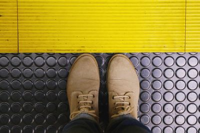 Low section of man standing on tiled floor