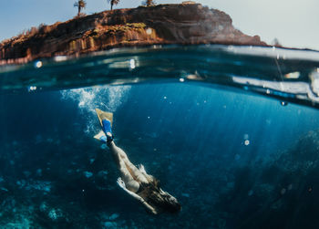 High angle view of woman scuba diving in sea