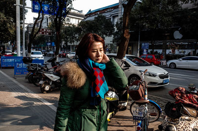 Young woman standing on street in city