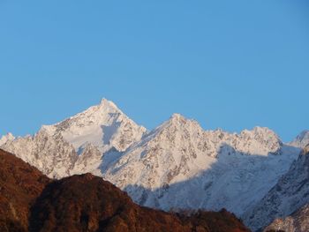 Scenic view of snowcapped mountains against clear blue sky