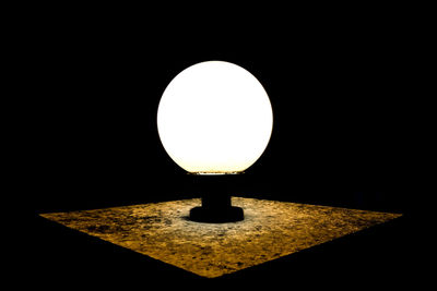 Close-up of illuminated lamp against black background