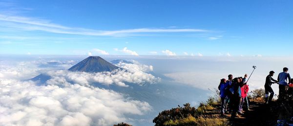 People on mountain against sky