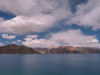 Scenic view of lake by mountains against sky