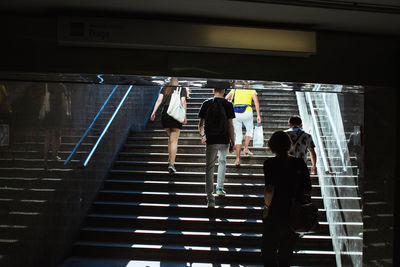 Rear view of people climbing on staircases in city