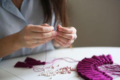 Craftswoman makes brushes from threads. concept creativity and handwork, toning in real interior