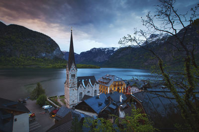 Buildings by lake against sky