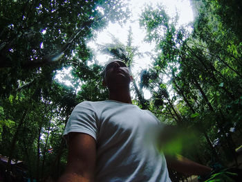 Low angle view of man walking in forest