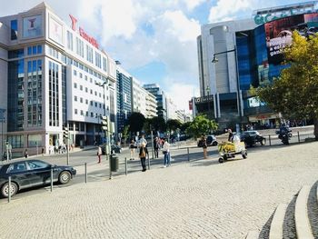 People on street against buildings in city